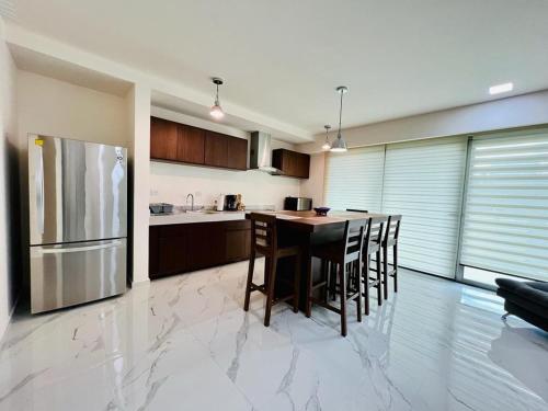 a kitchen with a table and a refrigerator at La Poza Condominio in Isla Mujeres