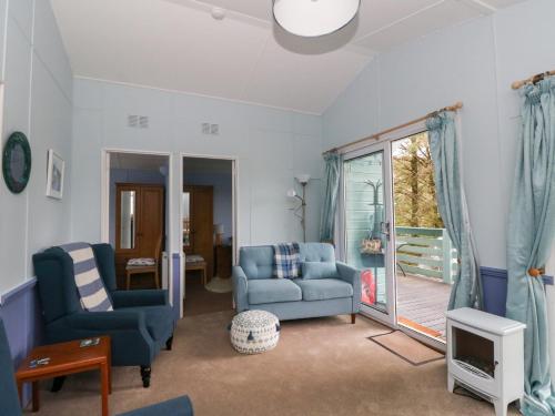 a living room with blue furniture and a sliding glass door at Scarba in Balvicar