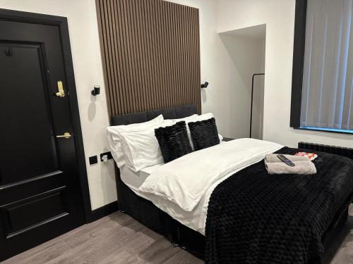 a bedroom with a bed with black and white sheets and pillows at 3M Luxury Living in Preston