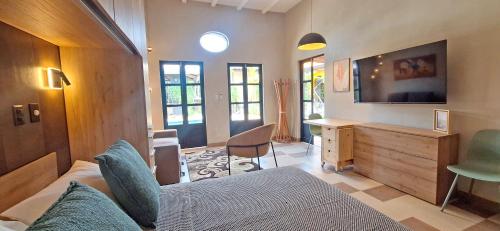 a room with a bed and a desk and a television at Club Heasa - Men Only in La Garita