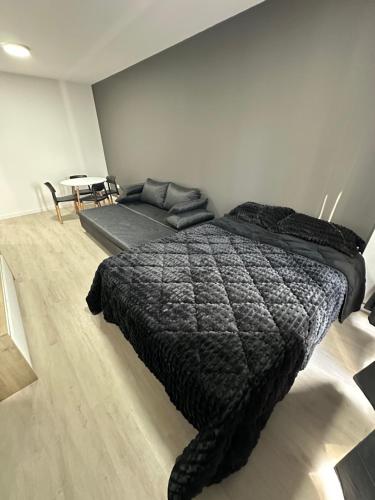 Schlafzimmer mit einem schwarzen Bett und einem Tisch in der Unterkunft MOVISTAR ARENA PREMIUM THAMES 56 7 piso 713 Cocheras y Seguridad in Buenos Aires
