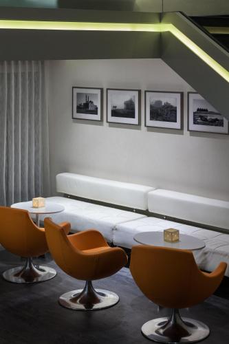 a room with a bed and two tables and chairs at The Atara Near Golf Course Road in Gurgaon