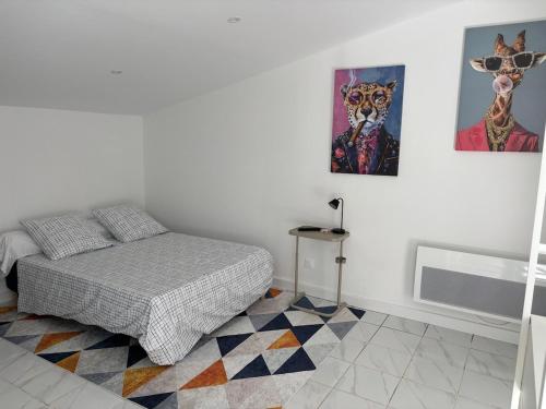 una camera da letto con un letto e quadri sul muro di Gutenberg's Nest a Carcassonne