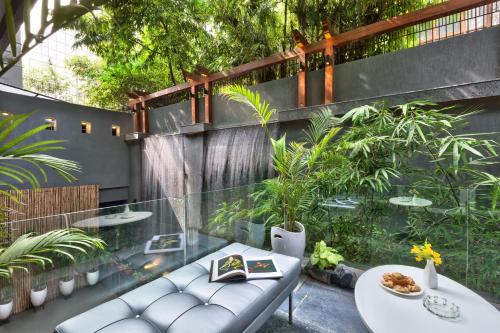 a patio with a bench and a table and plants at The Atara Near Golf Course Road in Gurgaon