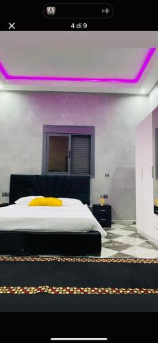 SraghnaにあるCasa kushのベッドルーム1室(紫色の照明が付いた大型ベッド1台付)