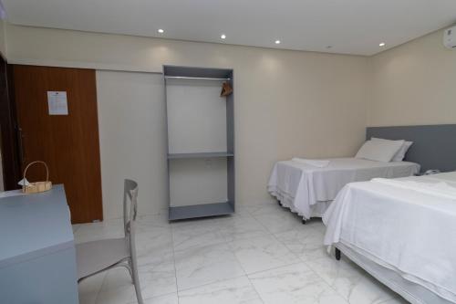 a hospital room with two beds and a glass door at Pousada Princesa do Sertão in Piranhas