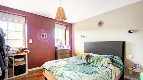 a bedroom with a bed and a red wall at Maison de ville in Saint-Pol-de-Léon