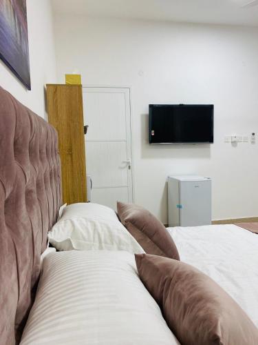 a living room with a couch and a flat screen tv at VIP Room2 in South Alhail - Muscat in Ḩayl Āl ‘Umayr