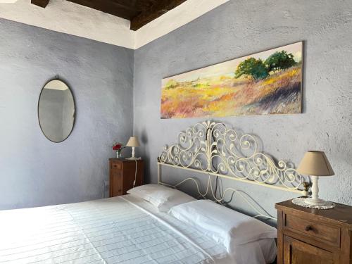 a bedroom with a white bed and a mirror at Agriturismo La Costa - Casa Vacanze in Perego