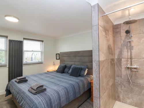 a bedroom with a large bed and a shower at Pilgrims Rest in Worle