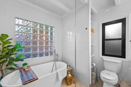 a bathroom with a tub and a toilet and a window at Luxe Beachside Escape Near Channel Islands in Hollywood Beach