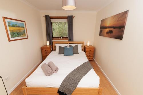 a bedroom with a large white bed with blue pillows at Millbrae, Lerwick in Lerwick