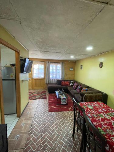 a living room with a couch and a refrigerator at Casa Cabaña Oro Rayado Puerto Varas in Puerto Varas