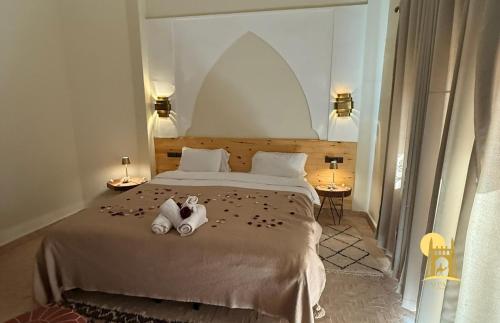 a bedroom with a bed with two teddy bears on it at hotel riad kasbah sbai palace in Mhamid