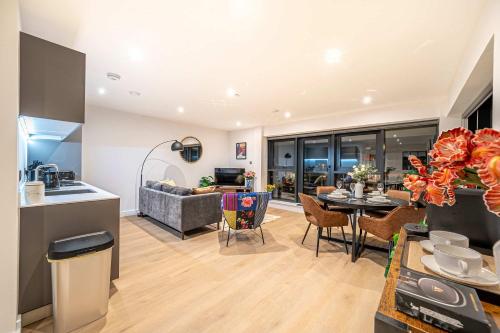 a kitchen and a living room with a table at Luxury 2BR Penthouse-1, Private Terrace, City Center, Free Parking in Leeds