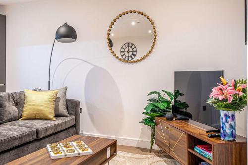 a living room with a couch and a mirror on the wall at Luxury 2BR Penthouse-1, Private Terrace, City Center, Free Parking in Leeds