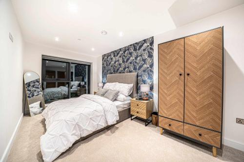 a bedroom with a large bed and a large closet at Luxury 2BR Penthouse-1, Private Terrace, City Center, Free Parking in Leeds