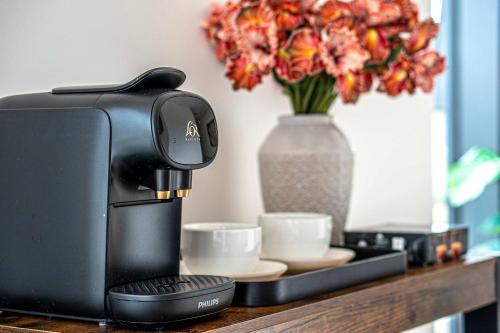 a coffee maker on a counter with a vase of flowers at Luxury 2BR Penthouse-1, Private Terrace, City Center, Free Parking in Leeds