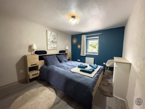 a blue bedroom with a bed and a desk at Le Maé classé 4 étoiles, terrasse et parking in Dole
