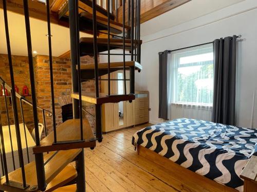 een slaapkamer met een stapelbed en een wenteltrap bij Mallison Cottage in Stalybridge