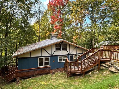 a blue and white house with a large deck at Cozy cabin with boosted Wi-Fi in Beech Mountain