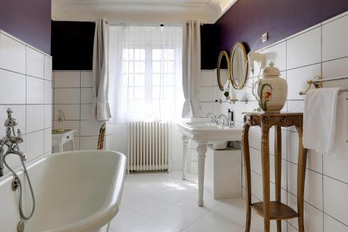 a white bathroom with a tub and a sink at Hattonchatel Château & Restaurant La Table du Château in Hattonchâtel