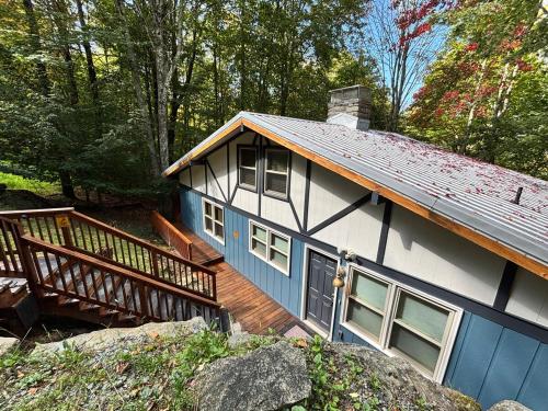 a blue and white house with a wooden deck at Cozy cabin with boosted Wi-Fi in Beech Mountain
