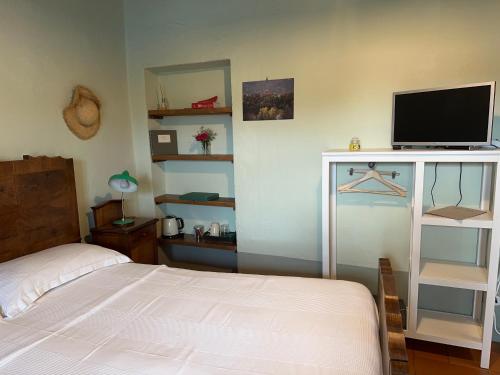a bedroom with a bed and a flat screen tv at Agriturismo La Costa - Casa Vacanze in Perego