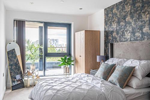 a bedroom with a bed and a large window at Leeds City Centre 2BR Apartment - Luxury Stay with Private Terrace in Leeds