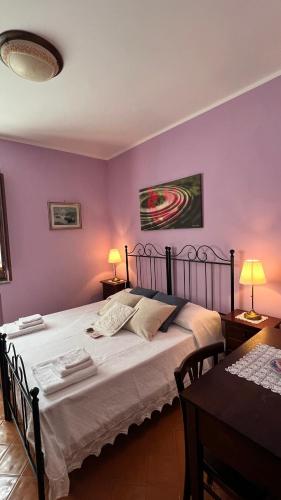 a bedroom with a large bed with purple walls at I Tre Tigli - Casa di campagna in Rutino