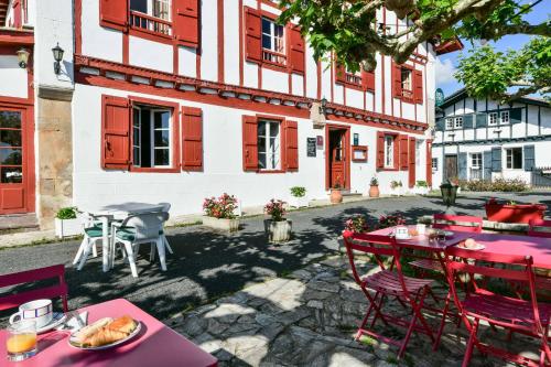 a group of tables and chairs in front of a building at Logis Hôtel Baratxartea in Sare