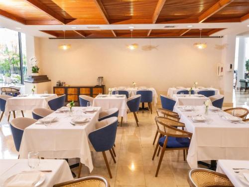 a dining room with white tables and chairs at Logis Auberge La Diege in Capdenac-Gare