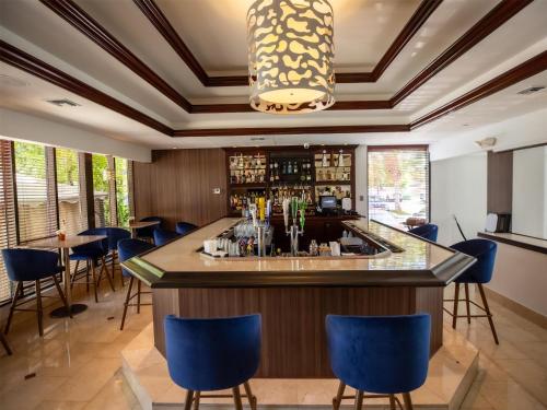 a bar in a restaurant with blue chairs at Logis Auberge La Diege in Capdenac-Gare