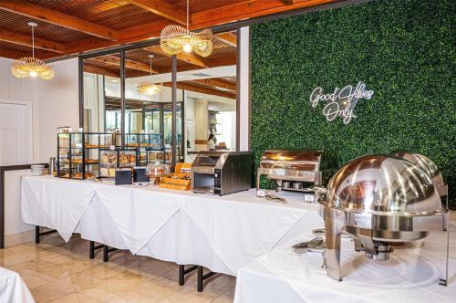 a restaurant with a long table with a food chef out at Logis Auberge La Diege in Capdenac-Gare