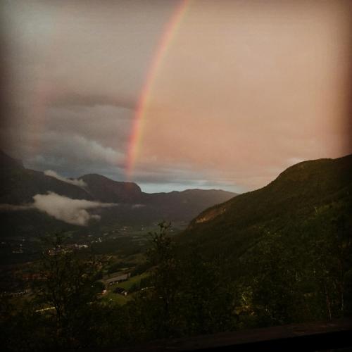 a rainbow in the sky over a valley at Skarsnuten Panorama 61, Hemsedal in Hemsedal