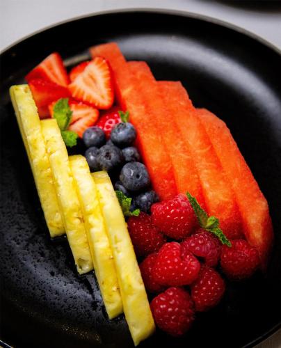 a black plate with fruit and vegetables on it at Logis Auberge La Diege in Capdenac-Gare