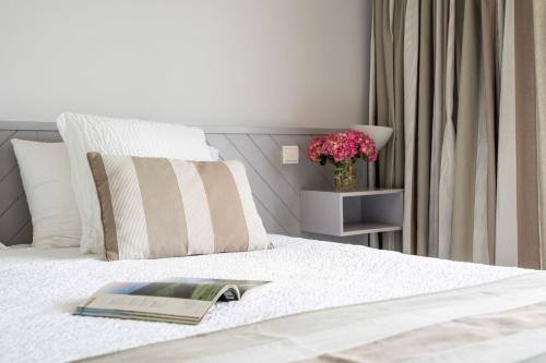 a book laying on top of a bed at Logis Hôtel Baratxartea in Sare