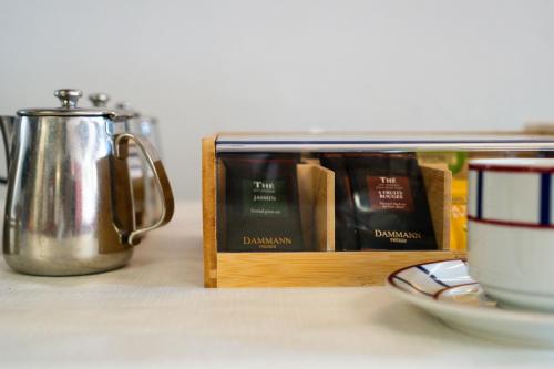 a wooden container filled with books next to a coffee pot at Logis Hôtel Baratxartea in Sare