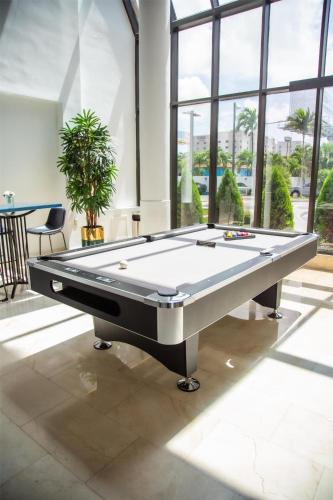 a pool table in a room with windows at Logis Auberge La Diege in Capdenac-Gare