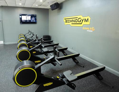 a gym with a row of treadmills and machines at Logis Auberge La Diege in Capdenac-Gare