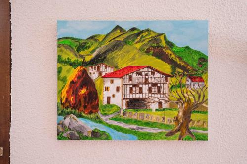 a painting of a house in front of a mountain at Logis Hôtel Baratxartea in Sare