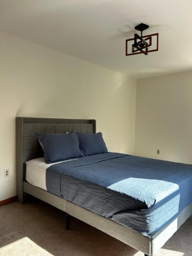 a bedroom with a bed with blue sheets and a ceiling fan at Welcome to your all season oasis in North Guilford
