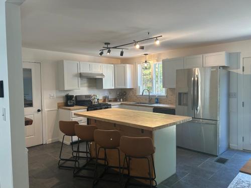 a kitchen with white cabinets and a island with bar stools at Welcome to your all season oasis in North Guilford