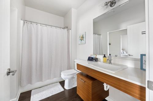 a white bathroom with a sink and a toilet at Trailside Haven @ Trailside45 in Traverse City