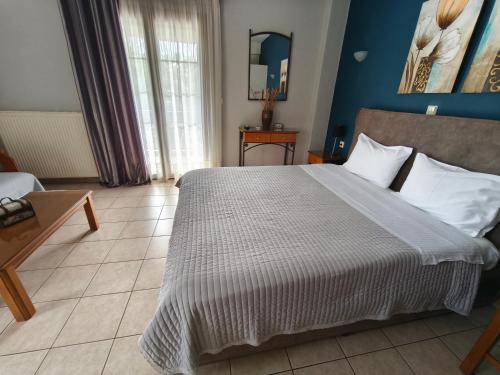 a bedroom with a large bed with blue walls at Zisis Garden Studios in Ioannina