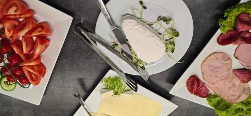 a group of plates of food with meats and cheese at Metropolis Apartamenty Centrum in Kalisz