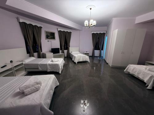 a large room with three beds and a chandelier at Keshtjella Duka in Rrëshen