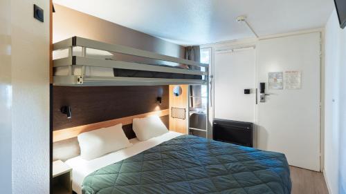 a hotel room with a bed with a blue blanket at Premiere Classe Bourges in Bourges