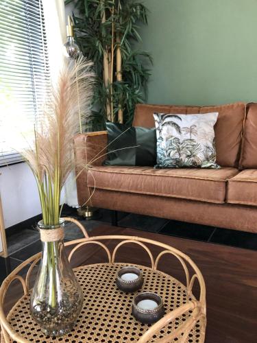 a living room with a table and a couch at Chalet Selesa Beekbergen in Beekbergen
