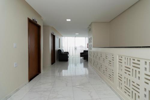 a hallway with white tile floors and a large screen on the wall at Pousada Princesa do Sertão in Piranhas